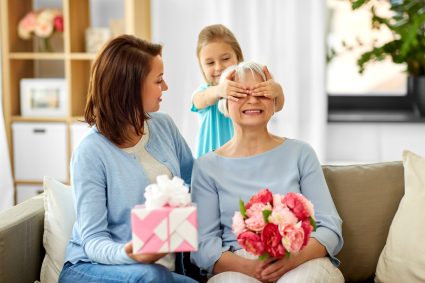 Mother And Daughter Greeting Grandmother At Home